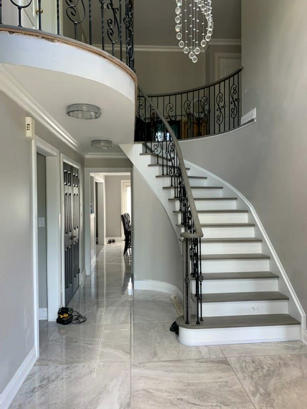 Curved staircase and marble floor in a completed home renovation