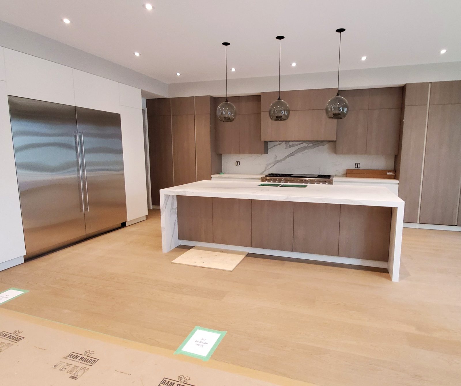 Custom kitchen with long waterfall island and pendant lighting